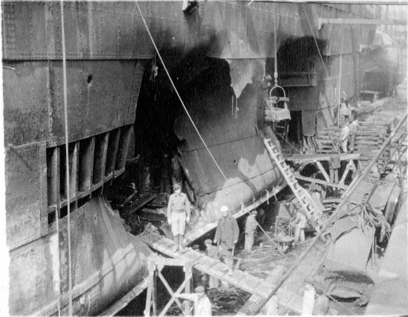A photograph of a damaged ship under repair harry s truman