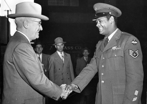 President Truman shakes hand of African-American Airman
