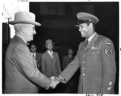 United States Air Force Staff Sergeant Edward Williams (right) of St. Louis, Missouri, exchanges a handshake with his Commander-in-Chief, President Harry S. Truman (left)