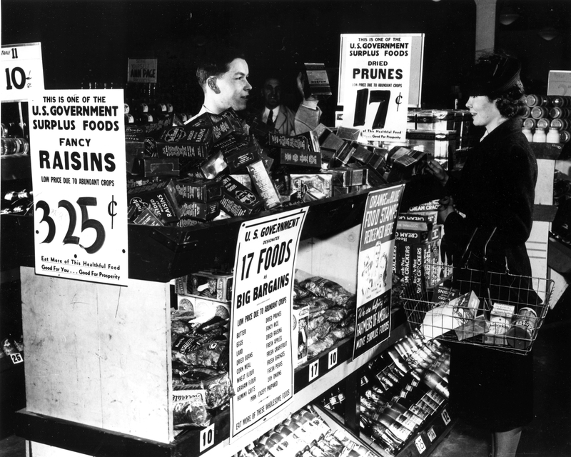 Grocery Store with Signs Advertising U. S. Government Surplus Food