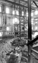 A bulldozer moves earth inside the shell of the exterior walls of the White House.